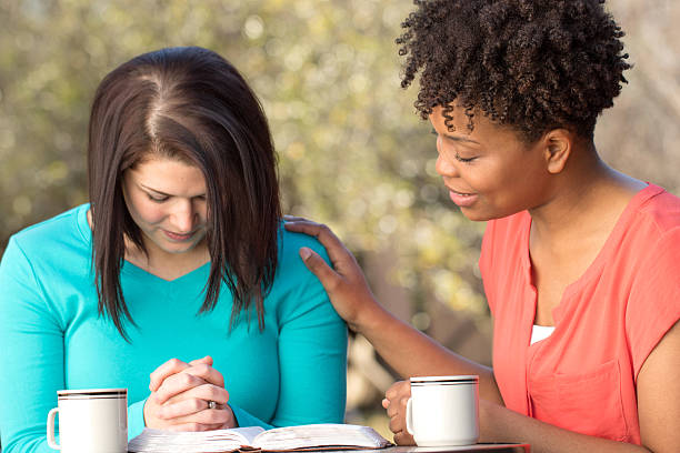 Women praying for each other.